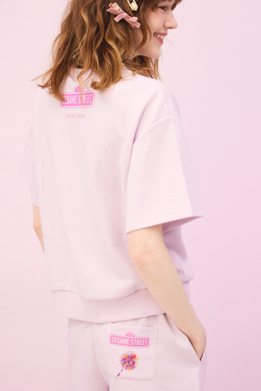 ピンクのセットアイテムとソックスを着用した女性