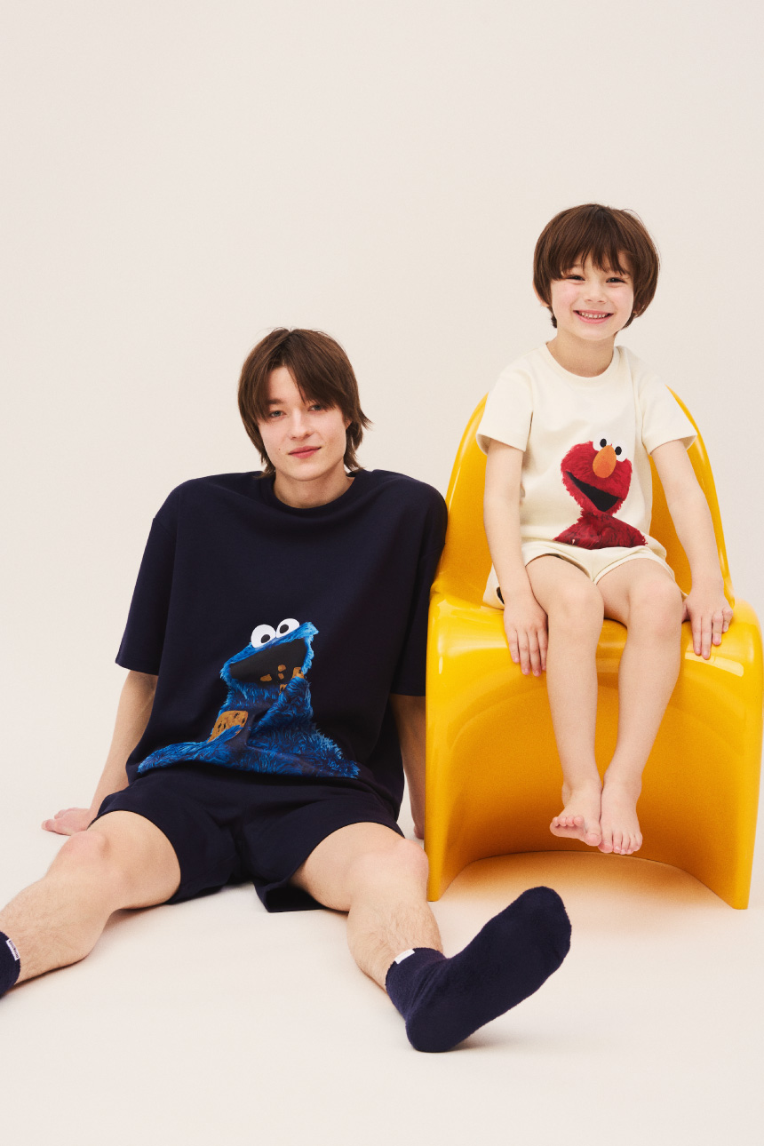 ネイビーのセットアイテムを着用した男性とイエローのセットアイテムを着用した子供